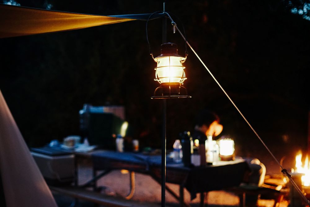 camping lantern at campsite with campfire