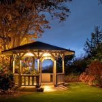 gazebo with lights on at night in a backyard