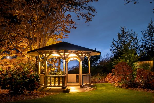 gazebo with lights on at night in a backyard